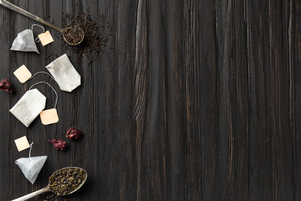 干绿茶和红茶，茶包上一个深色背景顶部视图复制空间。图片下载