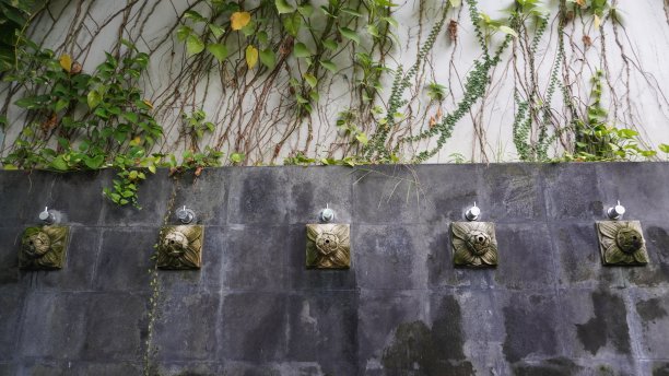 石墙上的艺术淋浴喷泉。装饰水龙头贴在石墙上，通常用于洗手、洗脚和洗脸图片下载