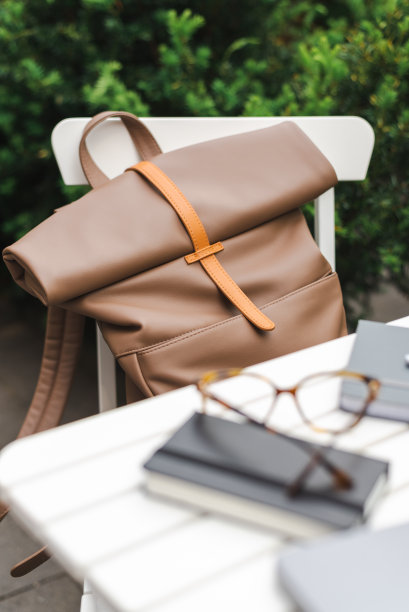 时尚的米色背包放在咖啡馆的椅子上。图片下载