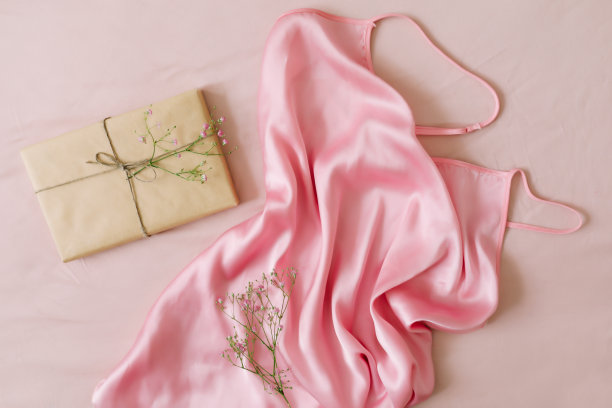 平面构图与优雅的粉色连衣裙，礼物，白色背景上的花朵图片下载