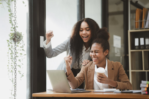 两个美国女人在一家初创公司的办公室里一起工作。他们正在一个联合部门举行头脑风暴和计划会议，由女性主导。妇女的工作观念。图片下载