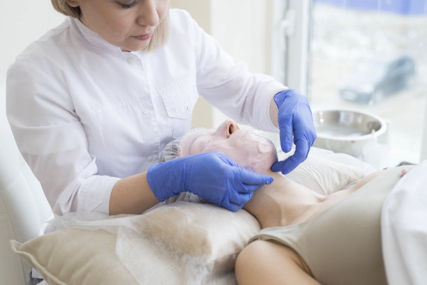 美容师在水疗中心从模特身上取下面具。图片下载