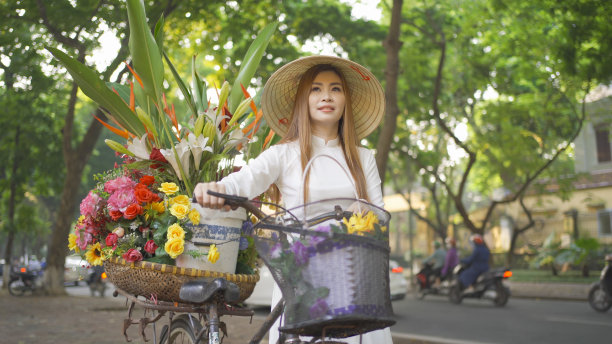 亚洲小贩的肖像自行车和鲜花，越南妇女女孩旅行在河内城市城镇，越南。人们的生活方式。图片下载