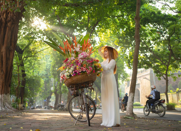 亚洲小贩的肖像自行车和鲜花，越南妇女女孩旅行在河内城市城镇，越南。人们的生活方式。图片下载
