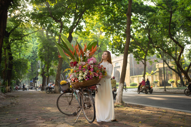 亚洲小贩的肖像自行车和鲜花，越南妇女女孩旅行在河内城市城镇，越南。人们的生活方式。图片下载