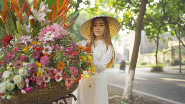 亚洲小贩的肖像自行车和鲜花，越南妇女女孩旅行在河内城市城镇，越南。人们的生活方式。图片下载