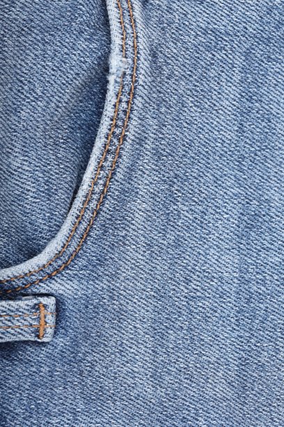 蓝色牛仔面料与侧双缝。在牛仔纺织品的背景线针。一个复制的地方。抽象的背景和纹理的设计。图片下载