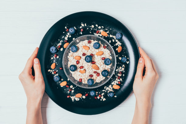 女人的手拿着一盘格兰诺拉麦片图片下载