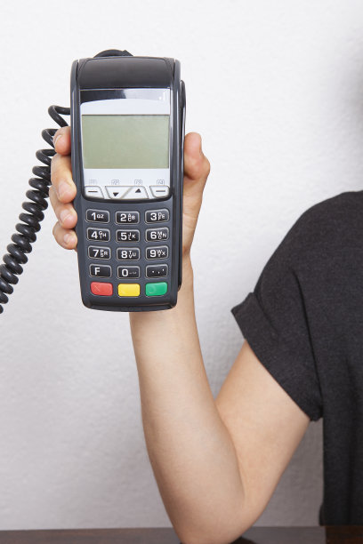 信用卡读卡器pos设备在木制背景。客户使用信用卡进行无线或非接触式付款。图片下载