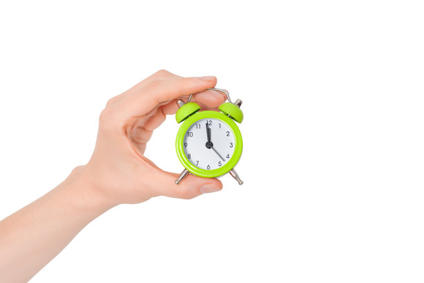 手拿一个小闹钟。时间管理的概念。白色背景的绿色闹钟。带有复制空间的横幅。图片下载