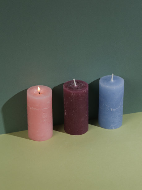 唯美的极简主义静物。三支彩色香薰蜡烛，绿色双色背景，带阴影。创造性的布局图片下载