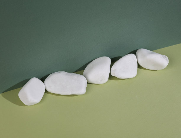 极简主义静物。美学成分。绿色双色背景上的卵石图片下载