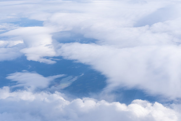 从飞机窗口看到的云和地面。地球表面的景观图片下载