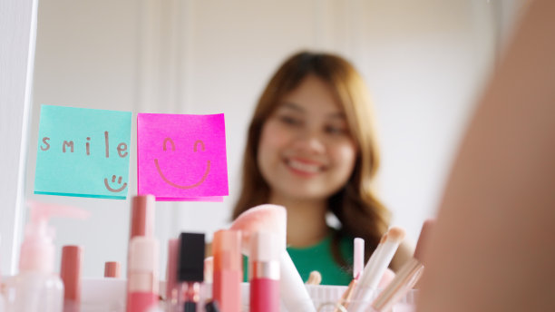 亚洲女性在镜子前用笑脸便签自言自语。图片下载