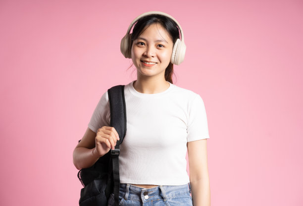 亚洲女学生在粉红色背景上摆姿势图片下载