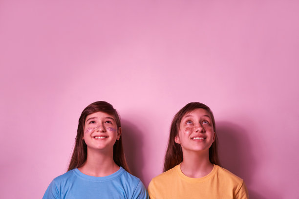 十几岁的女孩脸上带着亮片仰望着图片下载