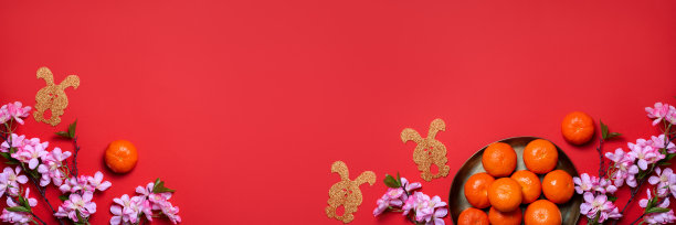 中国或农历新年的平铺上一盘桔子，纸兔子作为2023年的象征和红色的花朵图片下载