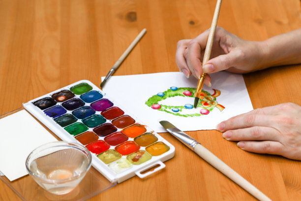 绘画是一种爱好。一个不认识的女人在家里画圣诞花环的特写照片图片下载