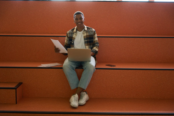 快乐的男学生在大学使用笔记本电脑图片下载