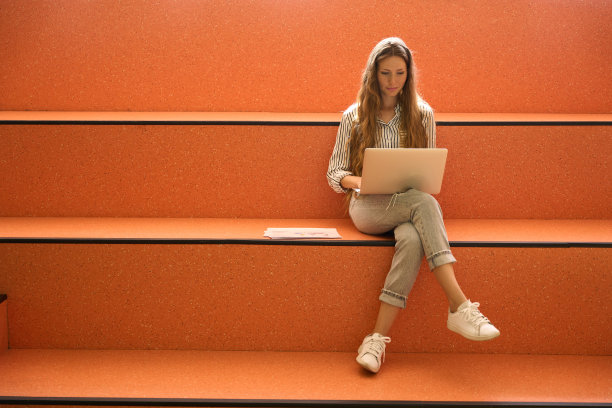 微笑的漂亮女士正在笔记本电脑上打字图片下载