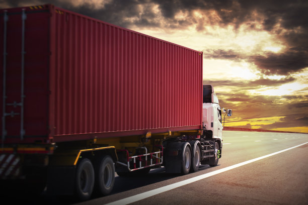 半挂车在道路上驾驶与日落天空。集装箱运输卡车。交付。发动机柴油卡车。卡车拖拉机。工业货车物流货物运输。图片下载