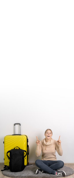 旅行团女游客穿着便装，背着旅行箱和背包，惊奇地抬起头，用两个食指指着复印处，指了指什么东西。境外旅客旅行。空中之旅图片下载