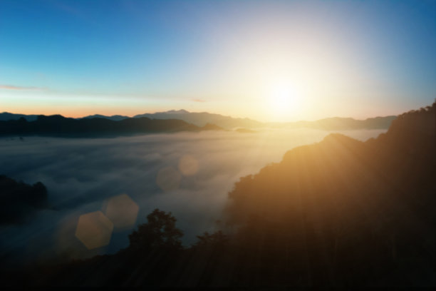 自然背景模糊暖色和明亮的阳光。散景或圣诞背景绿色能量在天空阳光的颜色橙色光图案朴素抽象耀斑傍晚云模糊。图片下载