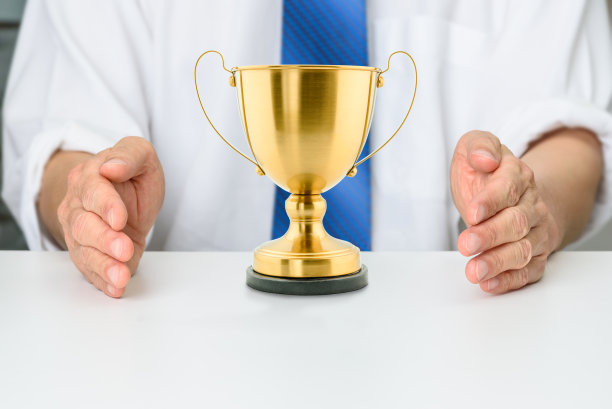 控制和支配一个市场，以保护产品和服务的市场份额和成功，企业垄断的概念:投资者或卖家或赢家用双手保护一个公司的金杯。图片下载