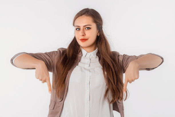 快乐的年轻女子指着手指下来，显示惊人的新闻，宣传横幅，提供。自信的女商人站在白色的工作室背景图片下载