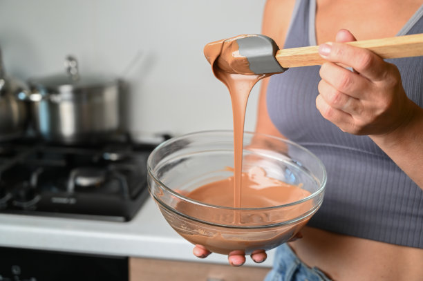 回火巧克力和制作巧克力的过程。糕点师正在用抹刀回火融化的巧克力图片下载