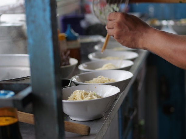 准备鸡肉面。一个铅笔mie ayam bakso或肉丸鸡面卖家正在为买家制作鸡面。有选择性的重点。图片下载