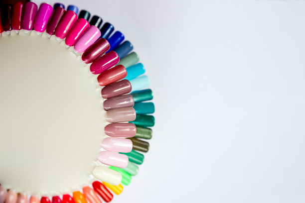 多色美甲，美丽的女性手指与美甲隔离在白色背景与复制空间。美甲艺术设计轮。一套假指甲。指甲油的颜色调色板。透明基础人工指甲。图片下载