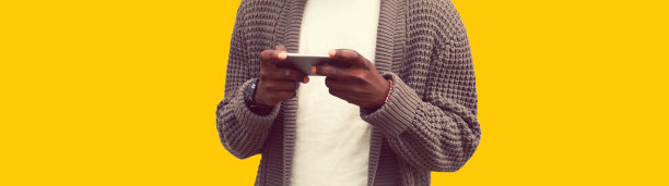 特写非洲男子与智能手机隔离在黄色背景图片下载