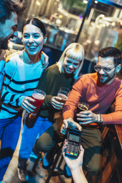 酒吧里形形色色的朋友用手机支付图片下载