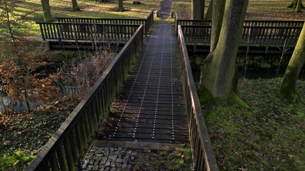 桥梁和人行天桥是受欢迎的自然景观。有栏杆的观景台，横跨河谷槽。砾石小径和花岗岩马赛克。十字形状，在溪流上方，树形，螺栓和螺母图片下载