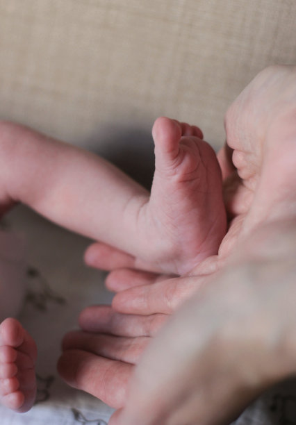 孩子的脚在妈妈、爸爸、父母手里。一个新生儿的脚。小娃娃腿。妈妈和她的孩子。幸福家庭理念。美丽的概念形象的母亲股票照片。图片下载