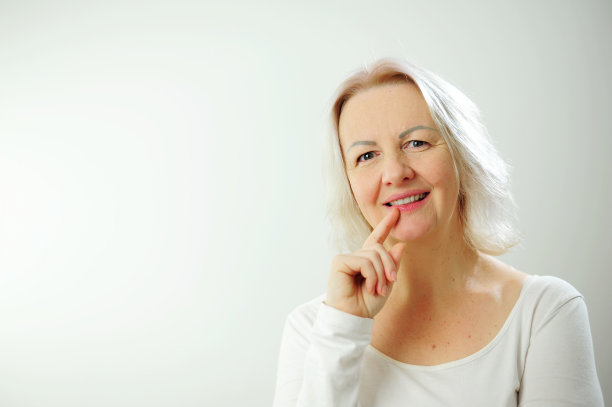 快乐快乐的成人美丽的女孩看着相机微笑着笑在白色背景美丽的偷拍女人短发，不化妆干净的面部皮肤微笑，站在t恤图片下载