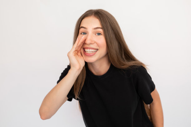 微笑的年轻女子用手捂住嘴的肖像图片下载