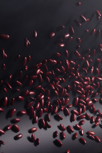 红豆炸飞爆，红豆爆抽象云飞。美丽完整的豌豆种子在空气中飞溅，食物对象设计。黑色背景高速快门定格动作图片下载