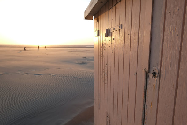 日落时分海滩上的一些海滩小屋。图片下载