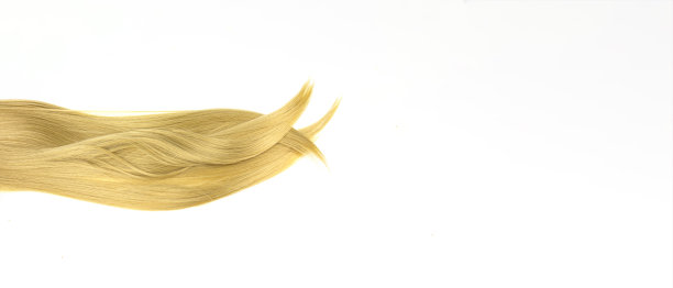 一缕白色的金发。卷发。白色背景的金色波浪发。图片下载