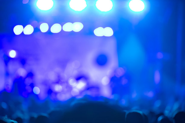 音乐会人群的剪影与舞台灯光，焦点模糊的照片图片下载
