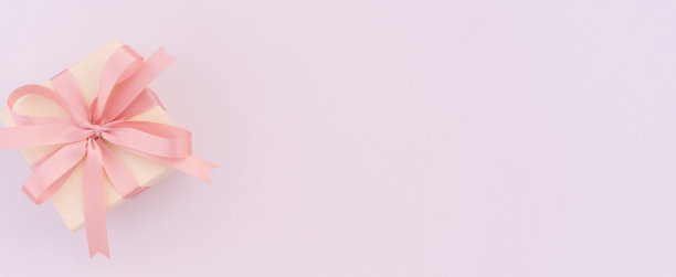 在情人节，国际妇女节和母亲节的概念上，在粉红色背景上的奢华米色礼盒上的特写图片下载