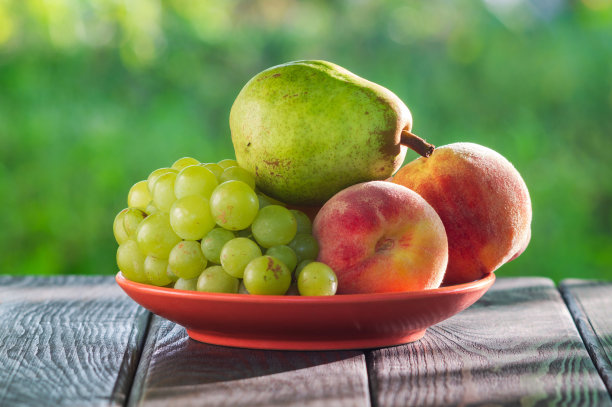 静物的桃子，葡萄和梨在收获后的木桌上图片下载