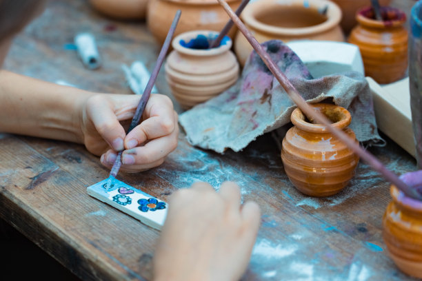 小女孩的手在画一块木头。图片下载