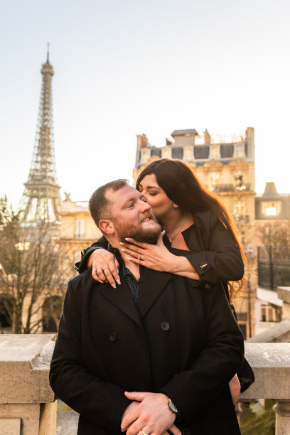 法国巴黎，这对幸福的情侣以埃菲尔铁塔为背景拍摄的垂直照片图片下载
