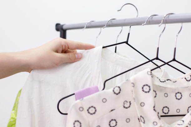 有人拿了一个挂着衣服的衣架在横梁上特写图片下载