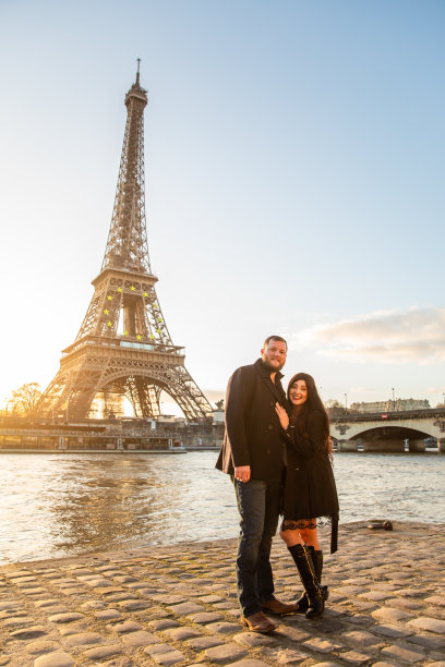 法国巴黎，这对幸福的情侣以埃菲尔铁塔为背景拍摄的垂直照片图片下载