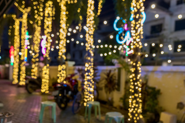 复古色调模糊图像的大排档在夜间节日与散景的背景使用。节日活动派对与人模糊的背景。图片下载