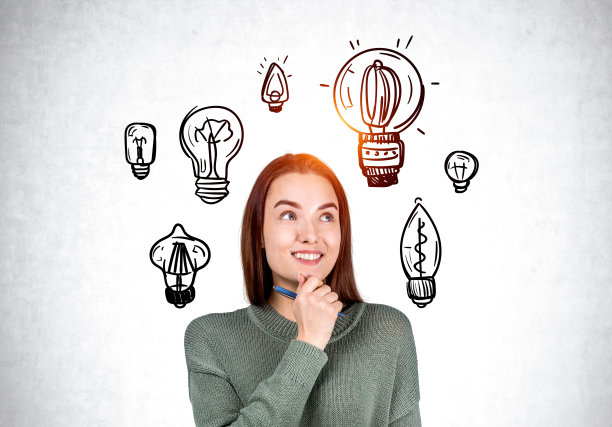 微笑的年轻女子和一组灯泡在灰色混凝土背景图片下载